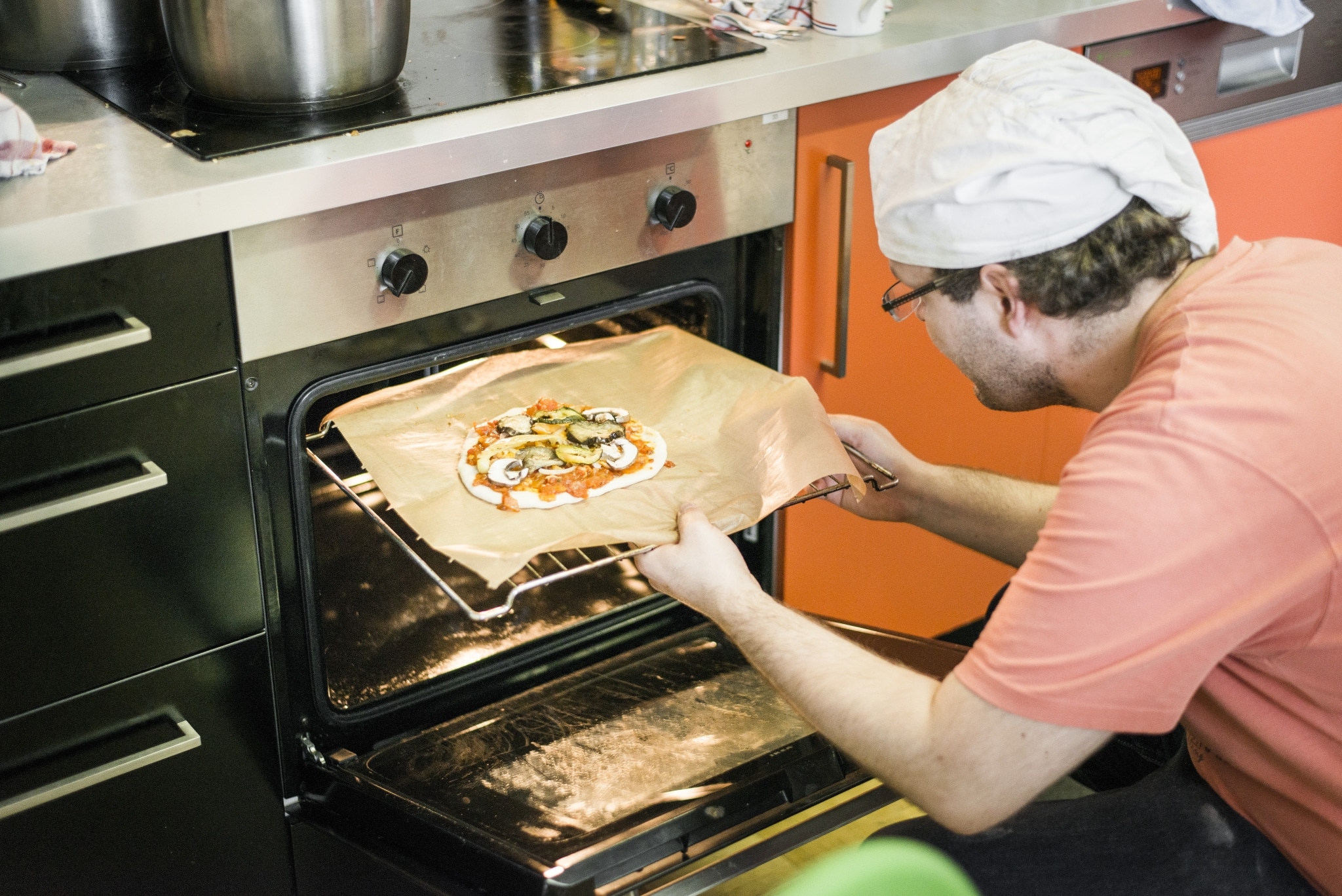 Kunde schiebt Pizza ins Backrohr